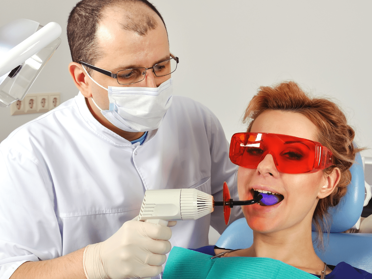 A dentist performing a tooth filling procedure on a patient.